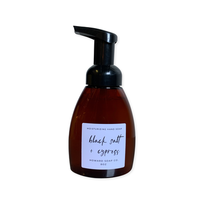 Product image of the Black Salt + Cypress Foaming Hand Soap. Plastic amber bottle with black pump