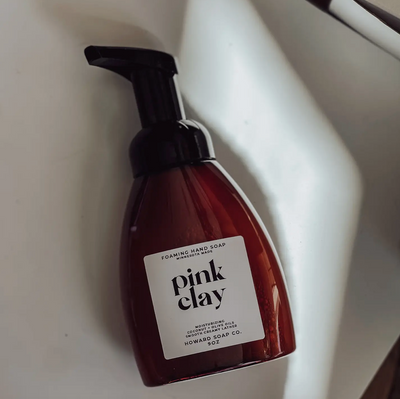 Product image of the Pink Clay Foaming Hand Soap. Plastic amber bottle with black pump
