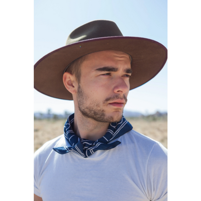 Person wearing a cowboy style hat with the navy blue "Good Luck" bandana worn around their neck.