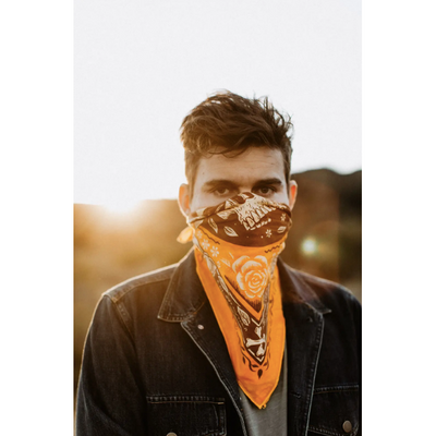 A man with brown hair wearing the "Free Spirit" bandana over his mouth and nose.