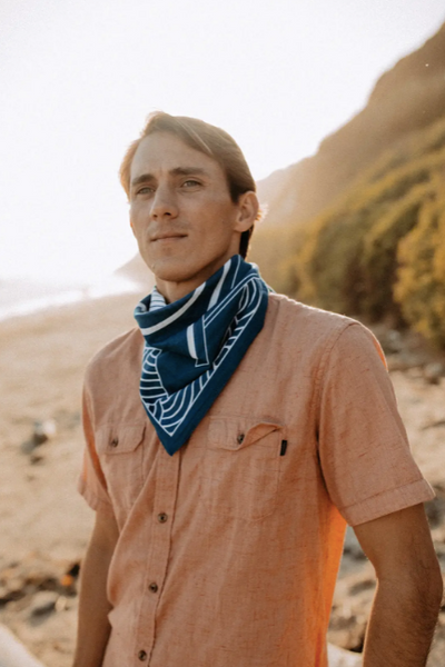 Photo of a person wearing the "Breaking Waves" bandana around their neck while on the beach.